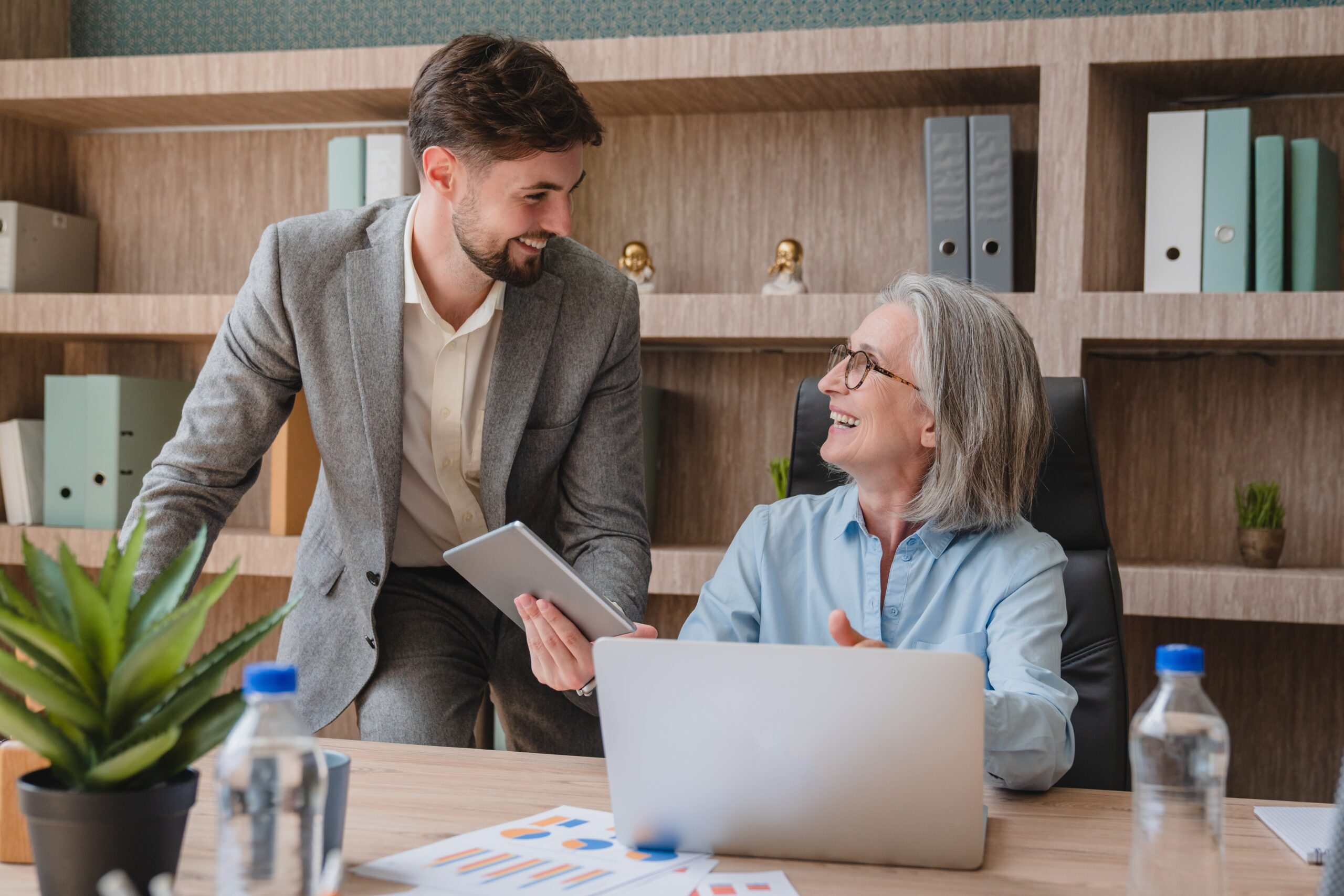 A business consulting leader in New Jersey happily discussing something to another professional.