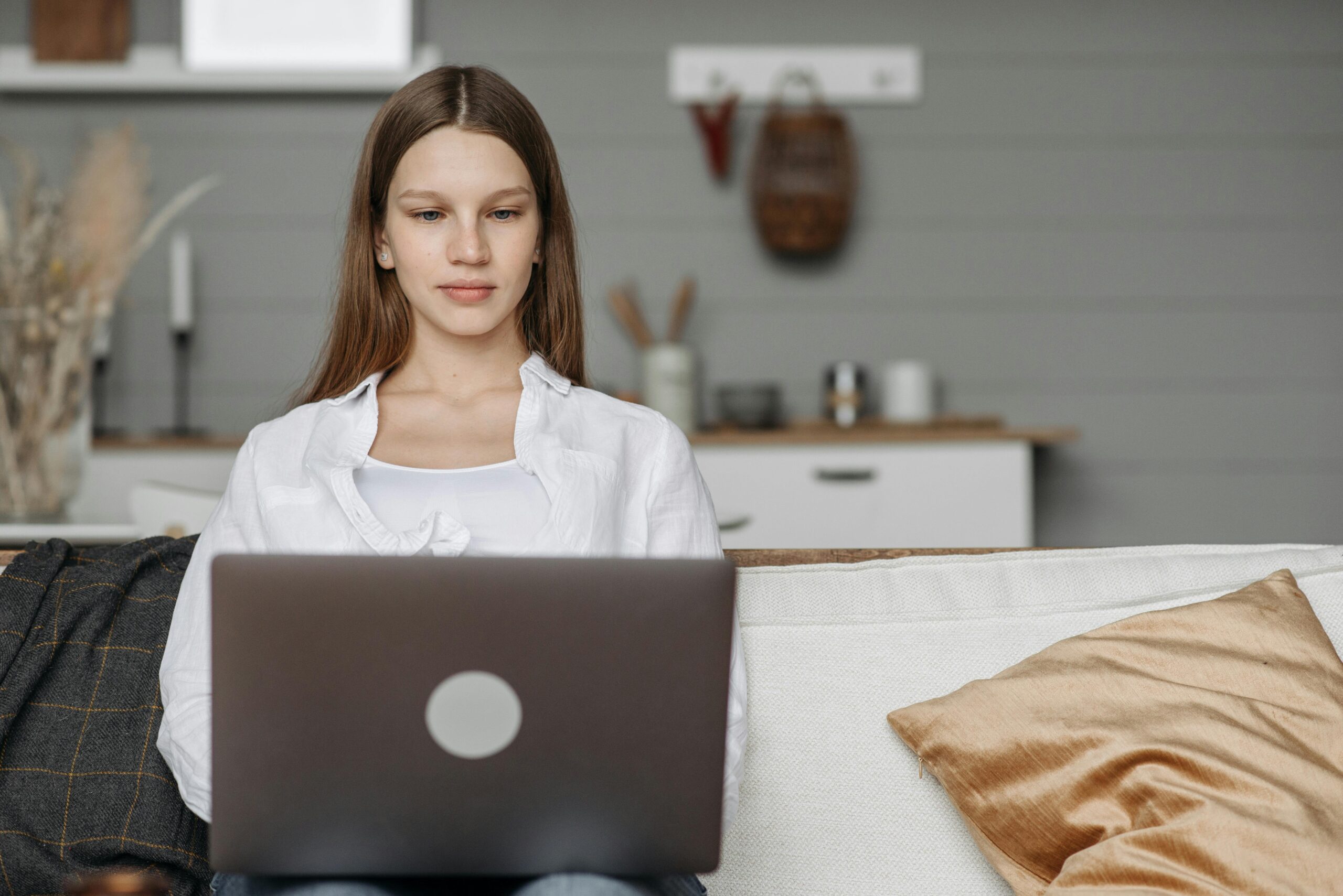A woman working on a laptop, researching how to spot authentic reviews of sales and marketing firms.